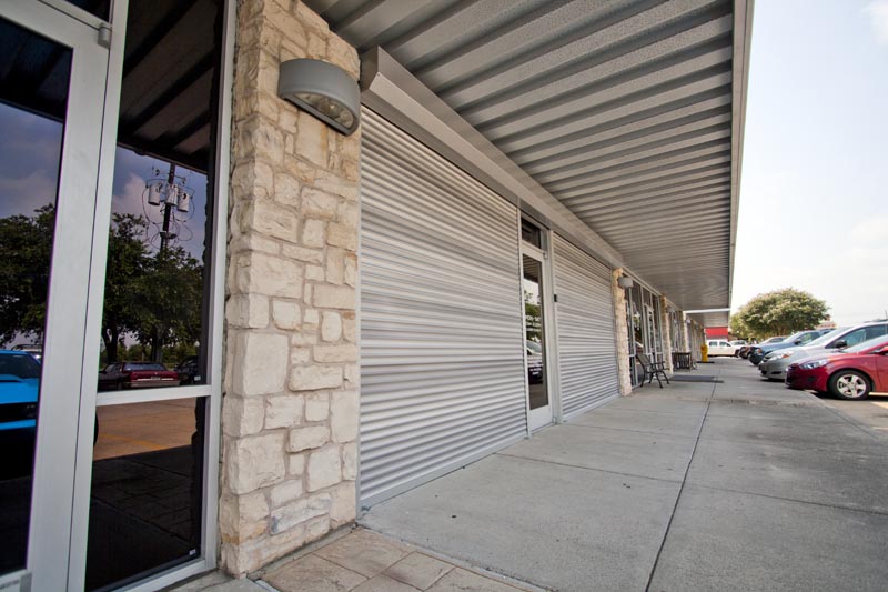 An image showing closed rolling shutters in the exterior of a commercial establishment