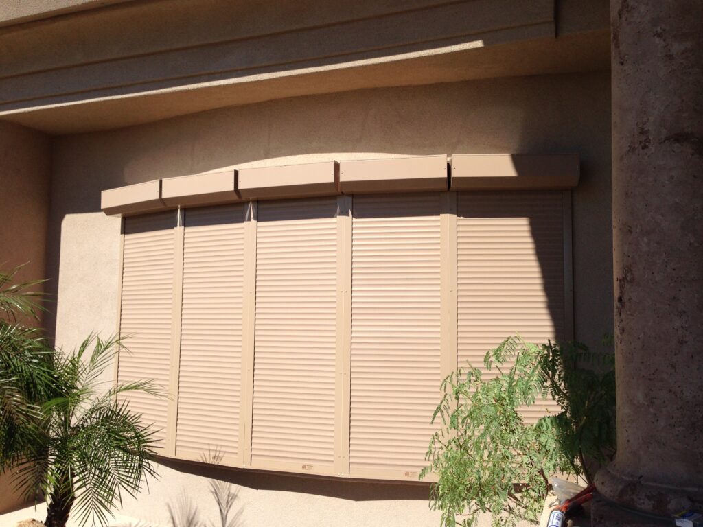 An image showing a row of rolling shutters installed outside of a residential home's windows to block out direct sunlight