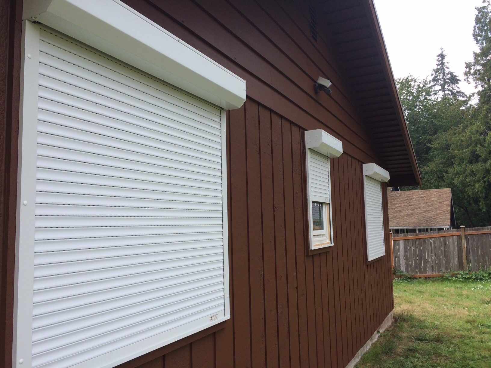 An image showing rolling shutters installed outside of a home's windows