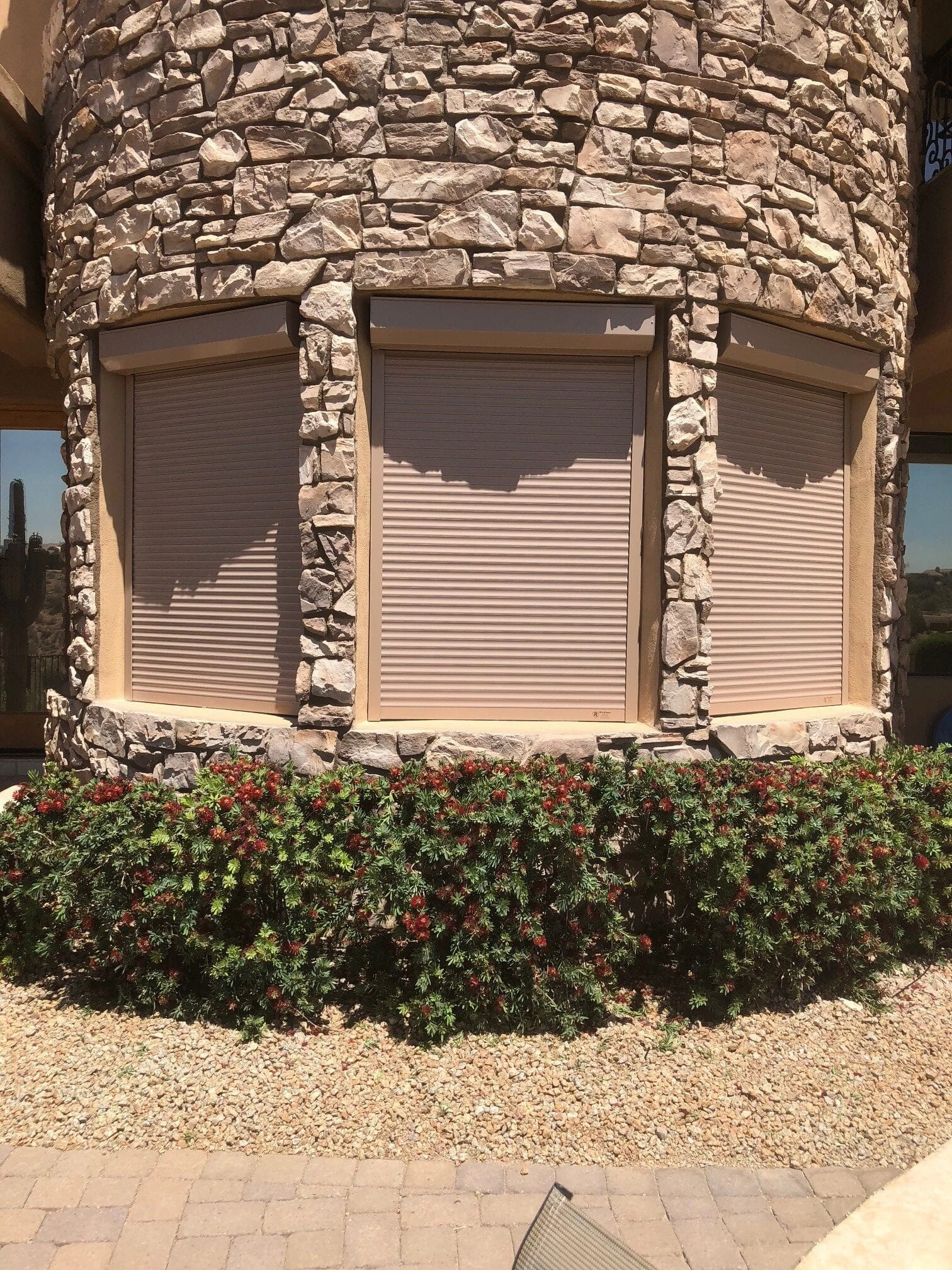 Bedroom window with rolling shutter installed in a Phoenix-area stone home