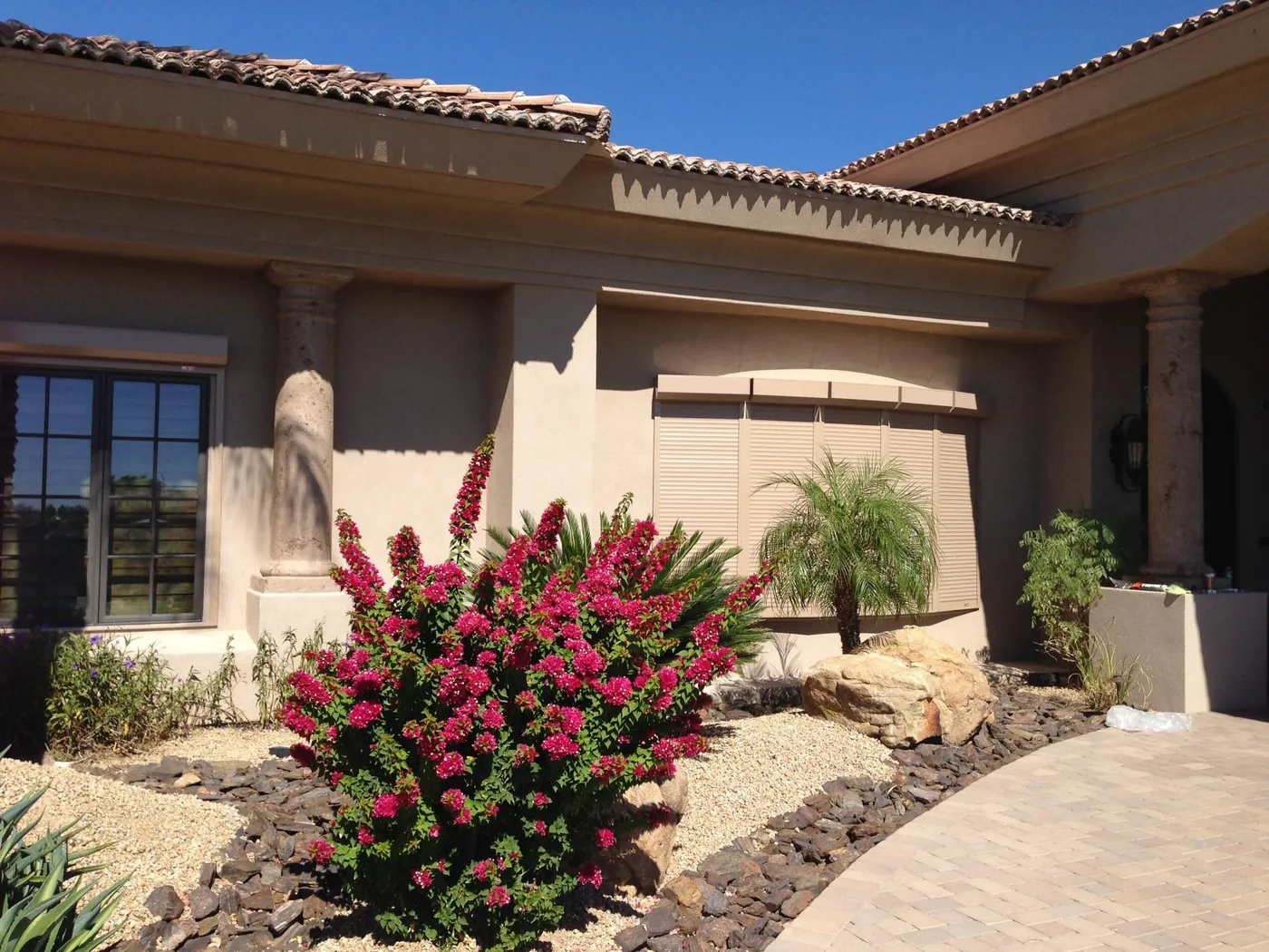 Rolling shutters fitted across the front of a desert-landscaped Phoenix home