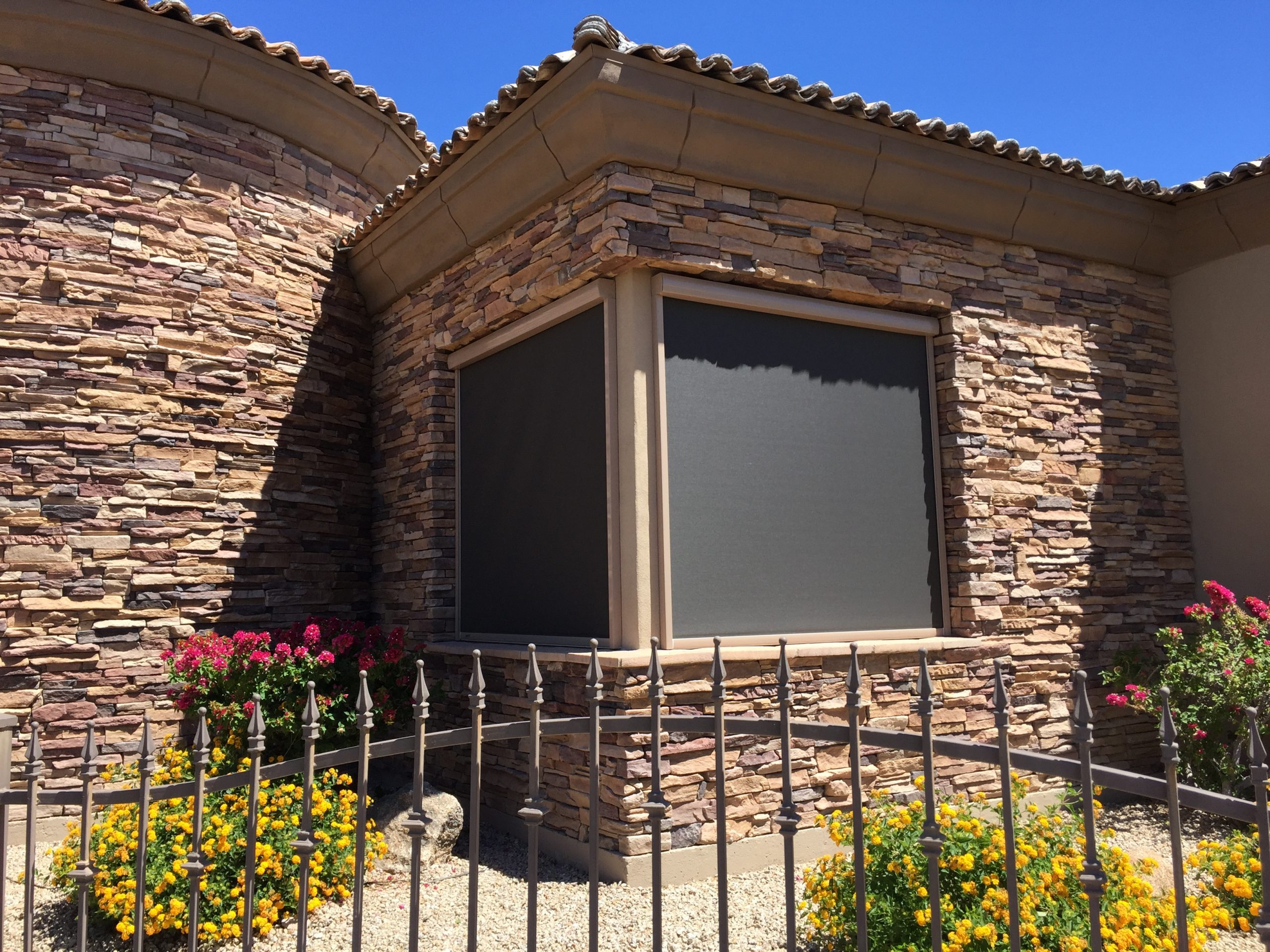 Recessed motorized retractable screen on Phoenix stone-veneer home