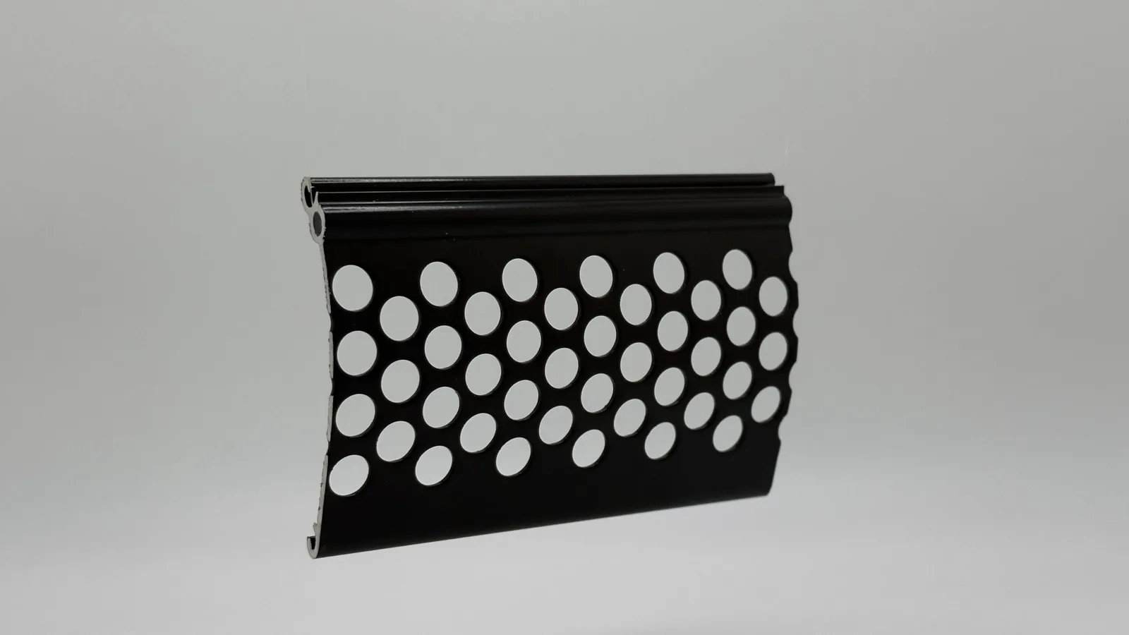 Slanted close-up of a Roll-A-Shield 63mm heavy-duty perforated aluminum slat that allows visibility and airflow on storefront motorized shutters