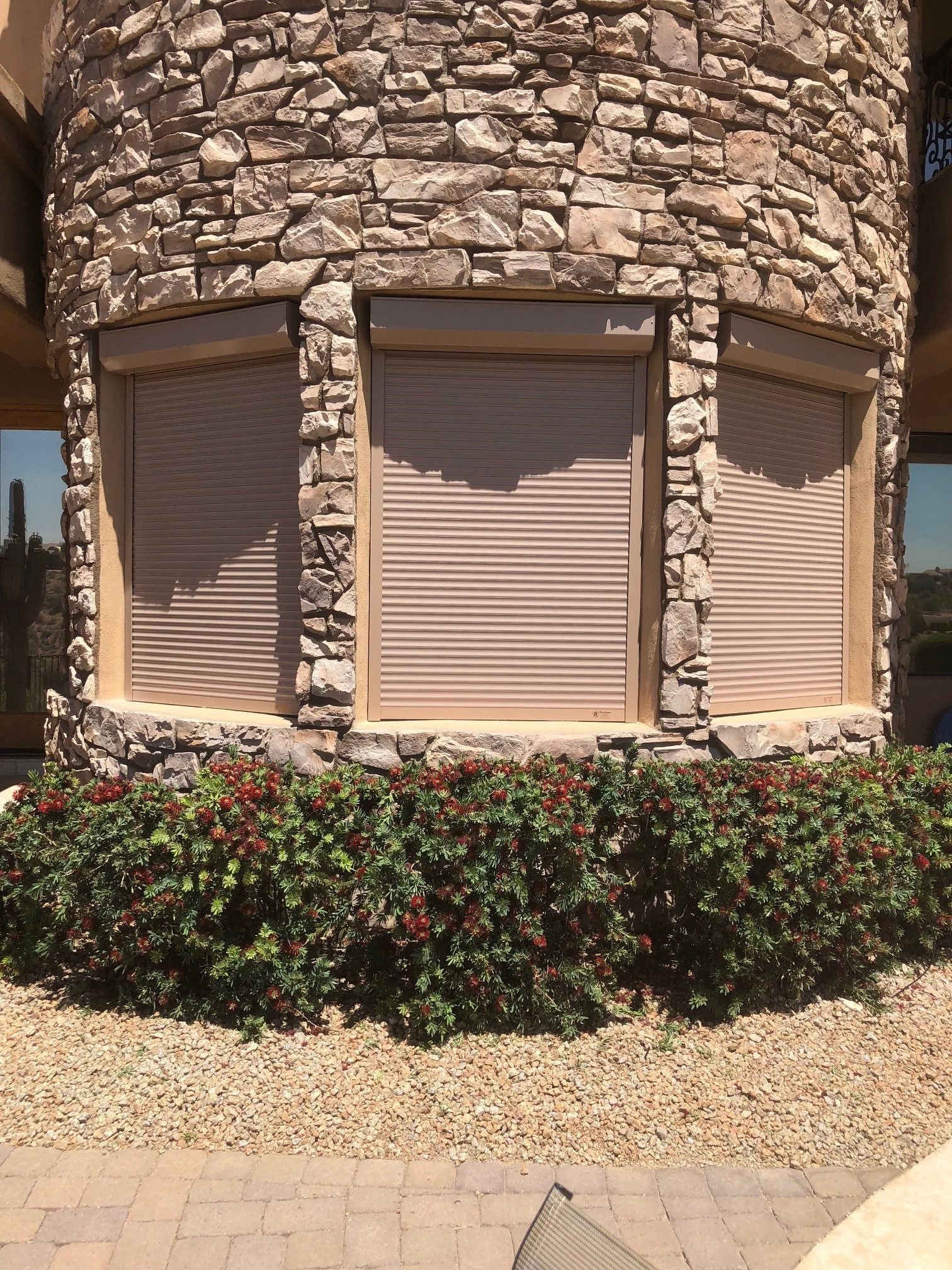 Standard residential window with rolling security shutters lowered for protection