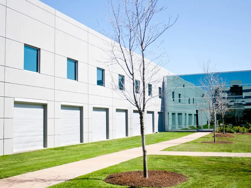 In-wall recessed rolling shutter installation on a new-construction multi-story facade