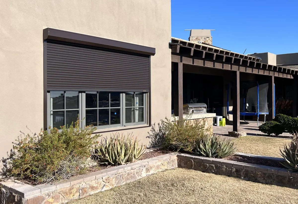 Bronze rolling security shutter installed on a desert home