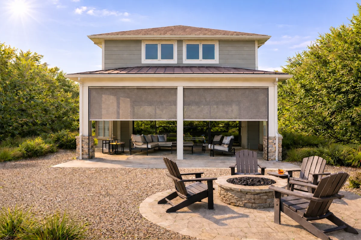 Patio screens enclosing a covered outdoor living room behind a backyard fire pit