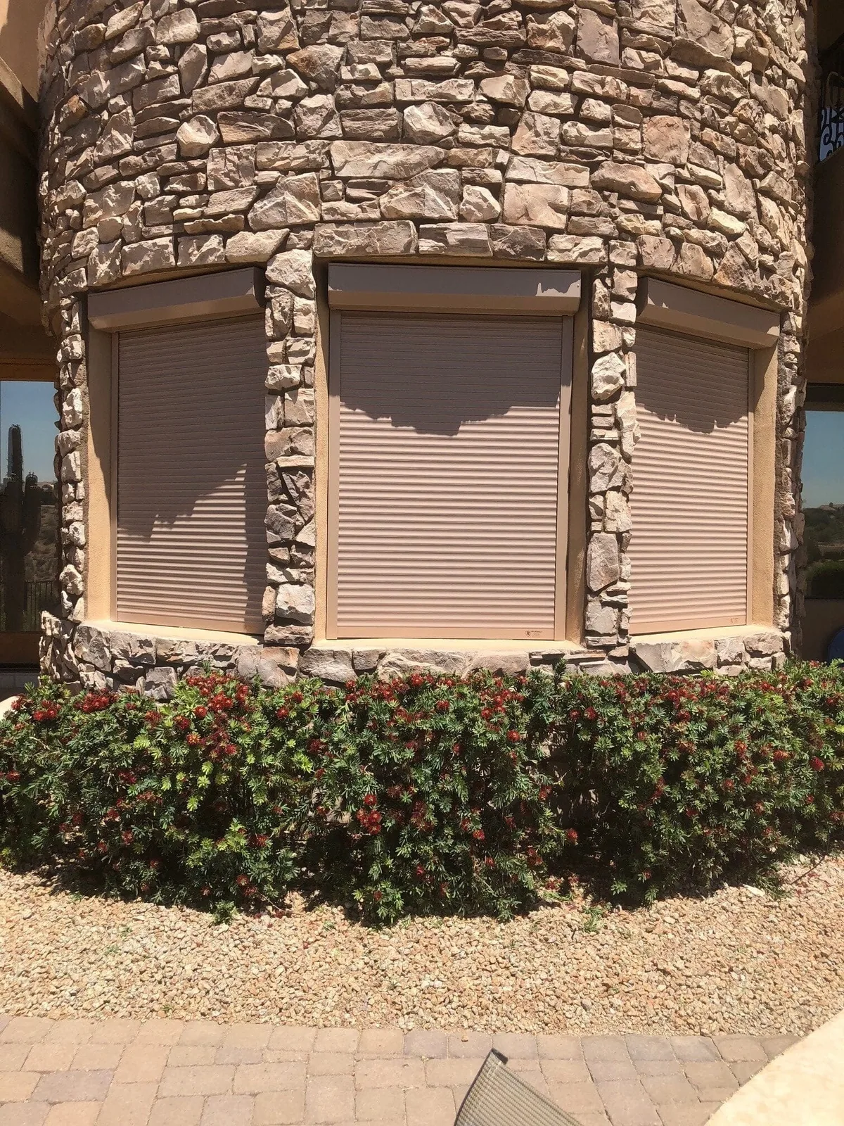 Bedroom window with rolling shutter installed in a Phoenix-area stone home