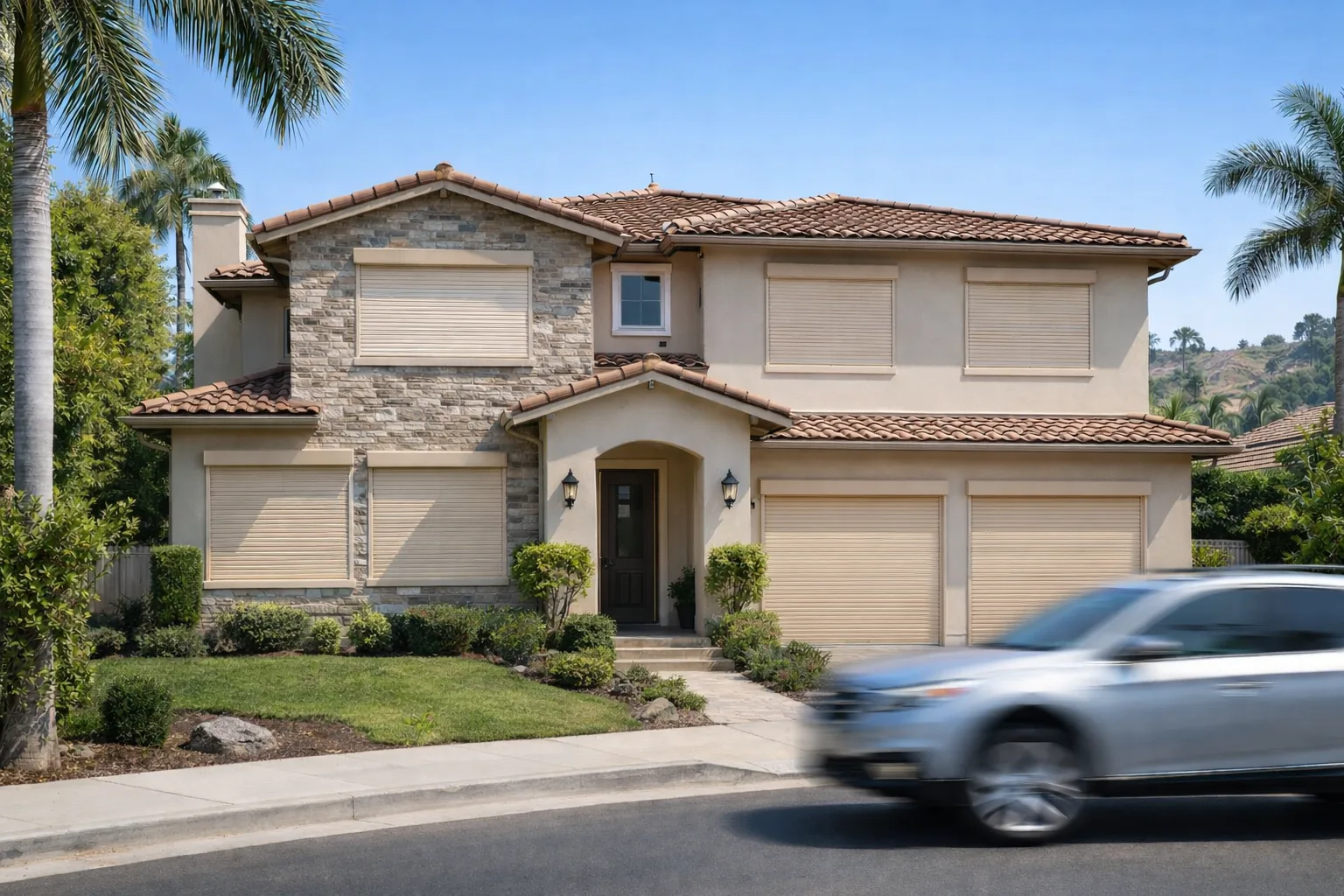 Cream rolling shutters closed over every window, the entry sidelights and both garage doors on a two story Metro Phoenix home, seen from the street