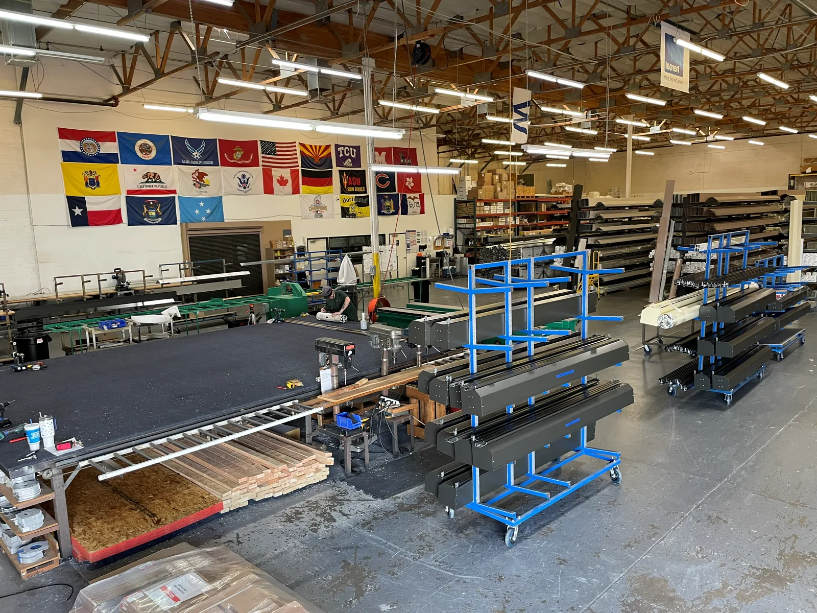 Finished rolling shutter curtains on carts across the shop floor of a rolling shutter facility