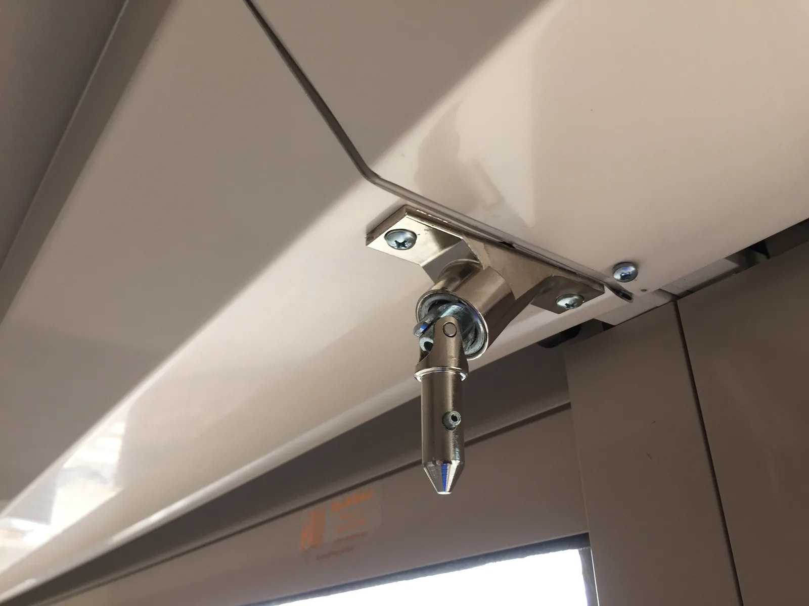 Manual override crank fitting mounted under a rolling shutter box, with its swivel joint and crank eye